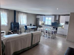 ein Wohnzimmer mit einem Tisch und einer Küche in der Unterkunft Finca Aideta- casa confortable con barbacoa 