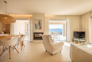 een woonkamer met een bank en een tafel en stoelen bij MOREMAR - Una Casa Especial Junto al Mar in Alcudia