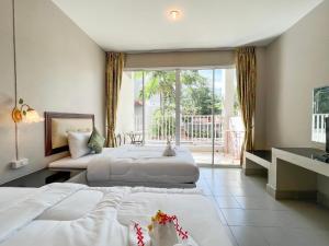 a hotel room with two beds and a balcony at Tri's Miracle Kata Beach Side in Kata Beach
