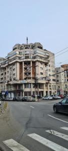 a large building with cars parked in front of it at City Apartment Cipariu in Cluj-Napoca