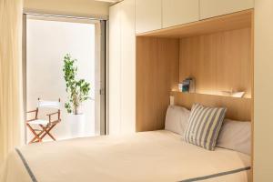 a bedroom with a bed and a balcony with a chair at MOREMAR - Una Casa Especial Junto al Mar in Alcudia