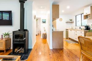 a kitchen and living room with a wood stove at Woodlands Seaside - Coastal Calm in Avoca Beach in Avoca Beach