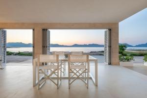 a dining room with a table and chairs and the ocean at MOREMAR - Una Casa Especial Junto al Mar in Alcudia