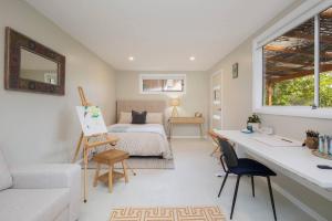 a bedroom with a bed and a desk and a room with a bed at Woodlands Seaside - Coastal Calm in Avoca Beach in Avoca Beach