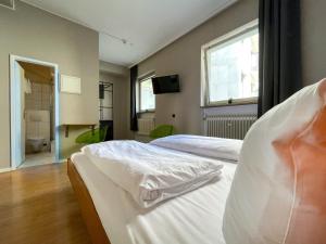 a bedroom with two beds and a bathroom at Hotel Sendlinger Tor in Munich