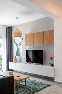 a living room with a large television and a table at Kition City Apartments - Central Location in Larnaca