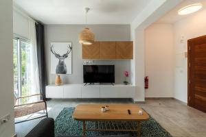 a living room with a table and a tv at Kition City Apartments - Central Location in Larnaca
