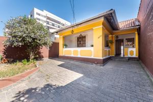 聖保羅的住宿－Casa da Cris，一座黄色和白色的房子,有一座建筑