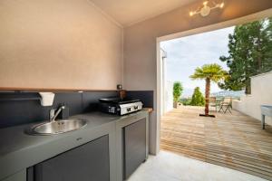 uma cozinha com um lavatório e vista para um pátio em CASA LC chambre1 vue Mer Jacuzzi em Ajaccio
