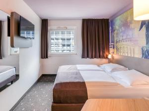 a hotel room with two beds and a window at B&B Hotel Stuttgart-Vaihingen in Stuttgart