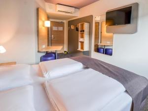 ein Hotelzimmer mit 2 Betten und einem Flachbild-TV in der Unterkunft B&B Hotel Stuttgart-Vaihingen in Stuttgart