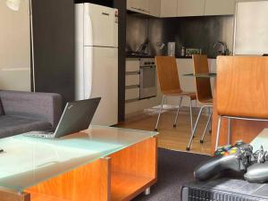 a kitchen with a table with a laptop on it at Spacious, Central 2 QB Melbourne CBD Apt near Flinders Stn, Town Hall in Melbourne