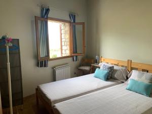 1 dormitorio con 2 camas y ventana en Casa Major, en Mont-ral