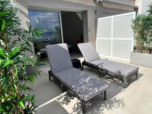 dwa krzesła i ławka na patio w obiekcie CASA LC chambre1 vue Mer Jacuzzi w Ajaccio