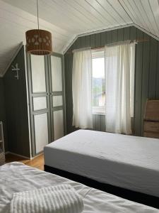 a bedroom with two beds and a window at Rigmorhuset in Fjordgård