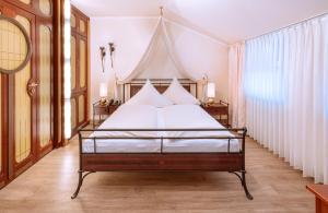 Schlafzimmer mit einem Bett mit weißer Bettwäsche und Kissen in der Unterkunft Hotel Neuwirt in Sauerlach