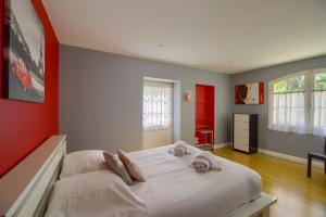 a bedroom with a large white bed with red walls at LA DEMEURE - Incroyable maison en bord de Dordogne in Saint-Loubès +35 photos
