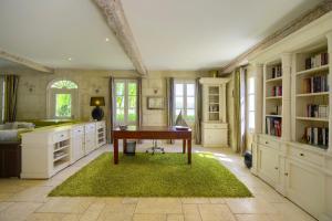 ein Heimbüro mit einem Schreibtisch und einem grünen Teppich in der Unterkunft LA DEMEURE - Incroyable maison en bord de Dordogne in Saint-Loubès