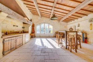 a large kitchen with wooden ceilings and wooden stools at LA DEMEURE - Incroyable maison en bord de Dordogne in Saint-Loubès