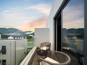 a balcony with chairs and a table on a roof at Tingting Lingshanjiang Light Luxury Art Homestay in Longyou