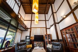 a living room with leather chairs and a television at Baikoen in Fukuoka