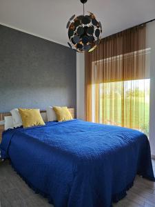 a blue bed in a bedroom with a large window at Tartu Pajuoja saunamaja in Tartu