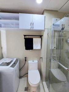 y baño con aseo y ducha acristalada. en 1 Bedroom in Pasay Mall of Asia- HAVEN GRACE, en Manila
