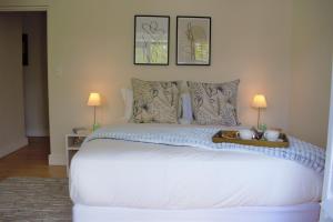 una camera da letto con un grande letto bianco con due lampade di Le Habitat 6 a Franschhoek