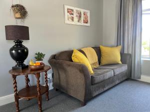 a living room with a couch and a table at Esme Road - WE HAVE NO LOADSHEDDING! in Cape Town