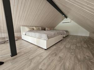 1 dormitorio con 1 cama y suelo de madera en Tartu Pajuoja saunamaja en Tartu