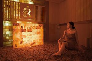 a woman sitting on the floor next to a brick wall at Rex Quang Binh Hotel in Dong Hoi