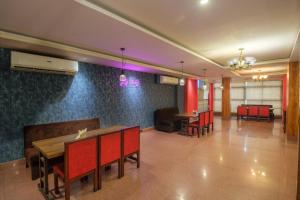 Parnil Palace في غاواهاتي: غرفة طعام مع كراسي حمراء وطاولة