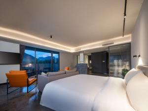 LongyouにあるTingting Lingshanjiang Light Luxury Art Homestayのベッドルーム(大きな白いベッド1台付)、リビングルームが備わります。