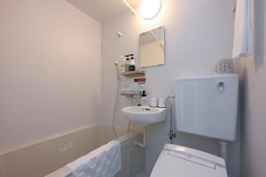 足利的住宿－HOTEL R9 The Yard Ashikagaekinishi，白色的浴室设有水槽和卫生间。