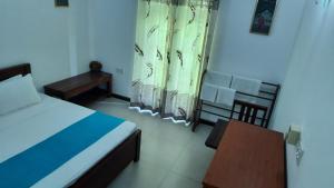 a bedroom with a bed and a table and a chair at CASA VACANSA HOME STAY in Hungama