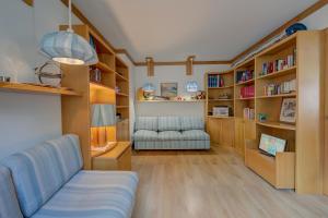 sala de estar con sofá y estanterías en Appartamento Alpetta 37 Ski In - Ski Out - Happy Rentals, en Sestriere