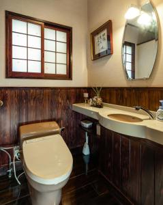 a bathroom with a toilet and a sink and a mirror at Baikoen in Fukuoka