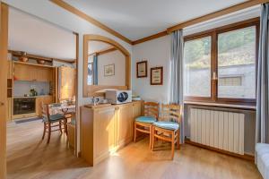 a kitchen with a table and chairs in a room at Appartamento Alpetta 37 Ski In - Ski Out - Happy Rentals in Sestriere