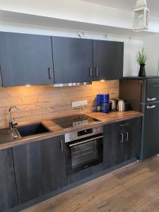 Una cocina con electrodomésticos de acero inoxidable y gabinetes de madera. en Artgerecht Ferienhäuser, en Bad Berleburg