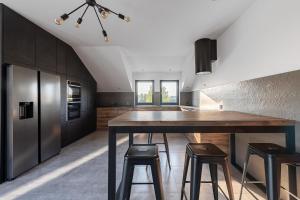 una cocina con una gran mesa de madera y taburetes en Apartament, en Długosiodło