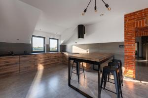 cocina con mesa de madera y pared de ladrillo en Apartament, en Długosiodło