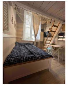 a bedroom with a bed in a room with a staircase at Przytulna kawalerka z antresolą w sercu Gdańska in Gdańsk