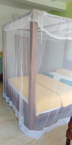 a bed with a canopy in a room at Jagabay Resort & Surfing School in Weligama