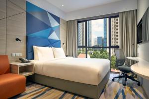 Holiday Inn Express Singapore Serangoon, an IHG Hotel في سنغافورة: غرفة فندقية بسرير ونافذة كبيرة
