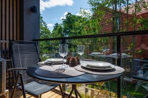 un tavolo con piatti e bicchieri su un balcone di Hill Namai a Palanga
