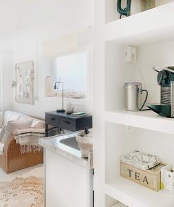 a kitchen with white walls and a sink in a room at ELSK Cottage in Zandvoort