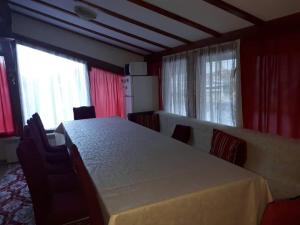 a dining room with a white table and chairs at Къща за гости Орфей in Smolyan