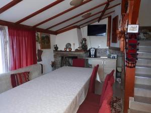 a room with a bed and a kitchen with a television at Къща за гости Орфей in Smolyan