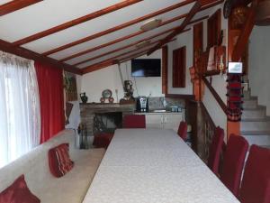 a dining room with a long table and red chairs at Къща за гости Орфей in Smolyan
