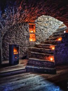 a stone room with stairs and a fireplace at Damelys in Gourdinne